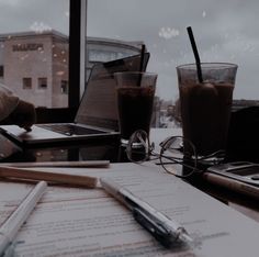 a table with papers, pen and laptop on it in front of a large window