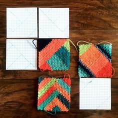 three crocheted bags sitting on top of a wooden table next to white paper