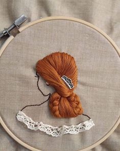 a close up of a ball of yarn on a table with a needle and thread