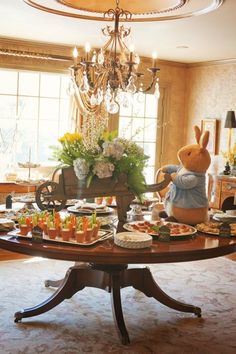 a dining room table with food on it and an inflatable bunny sitting at the center