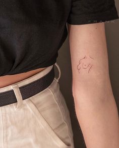 a woman's arm with a small tattoo on the left side of her arm