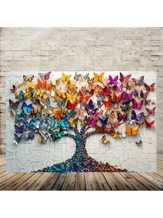 a colorful tree made out of butterflies on a white brick wall with wooden flooring