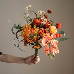 a person holding a bouquet of flowers in their hand