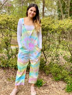 "Welcome All! This listing is for a made to order yellow, blue, and pink swirl Jumpsuit. Jumpsuits are handmade and hand died to order- please enter your size in the personalization box. Jumpsuits are handcrafted from polyester/cotton and will not bleed or shrink in the wash (wash cold water only and dry on low heat inside out or hang to dry).  The Jumpsuit is light and breathable with pockets The Jumpsuit pictured is a size small (please refer to measurement chart that lists the garment measurements for each size) Indicate size & whether you would like tie up adjustable straps or the standard button strap (17.5\") in the personalization box (XS-2XL standard) *if not specified adjustable tie up is the default* Any Size can be made!! Should you find this Jumpsuit attractive, but it is not y Tie Dye Overalls, Jumpsuit With Pockets, Boho Jumpsuit, Tie Dye Jumpsuit, Womens Jumpsuits, Pink Swirls, Blue Ties, Blue Tie Dye, Blue And Pink