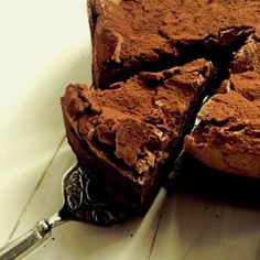 a piece of chocolate cake sitting on top of a white table