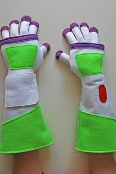 two hands wearing green and white gloves with red dots