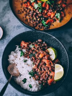 two bowls filled with rice, beans and limes