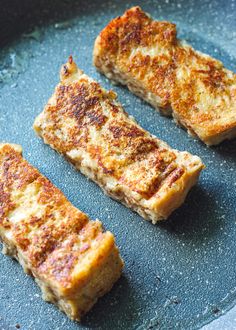 four pieces of food cooking in a frying pan