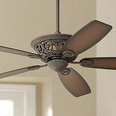 a ceiling fan that is hanging from the ceiling in a room with beige walls and white trim