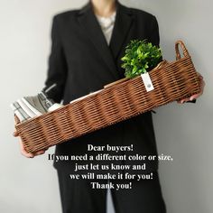 a person in a suit holding a wicker basket filled with silverware and plants