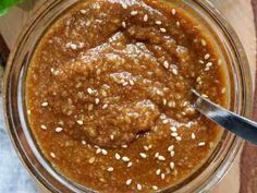 a glass jar filled with peanut butter and sesame seeds