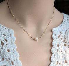 This romantic necklace combined intricately detailed 14kt gold filled satellite chain and a lustrous hand wired freshwater pearl.  The pearl is approximately 6 mm in size.  Please note that all metal material is gold filled.  Gold filled is high quality and lasting, not to be confused with gold plated brass. You may select your length when you add the item to your cart.  Note: most chokers are 14 or 15 inches.  Short necklaces are typically 16 inches. Standard necklaces are 17 or 18 inches.   Th Delicate Pearl Necklace With Satellite Chain, White Pearl Necklace With Satellite Chain, Delicate Wire Wrapped Pearl Necklace As Gift, Delicate Wire Wrapped Pearl Necklace For Gift, Gold Pearl Necklace With Satellite Chain In Dainty Style, Pearl Satellite Chain Necklace As Gift, Pearl Necklace With Satellite Chain As Gift, Gold Wire Wrapped Pearl Necklace For Wedding, Delicate Gold Wire-wrapped Pearl Necklace