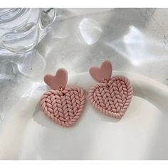 pink heart shaped earrings with gold accents on a white plate