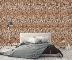 a leopard print wallpaper in a bedroom with a bed and lamp on the floor