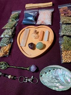 various items are laid out on a purple table cloth, including beads, stones, and glassware