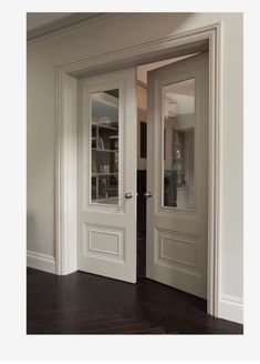 two white doors are open in an empty room