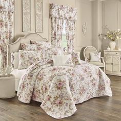 a bedroom with white furniture and flowers on the bedspread, curtains, and windows