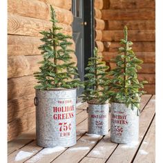 three tin cans with christmas trees in them