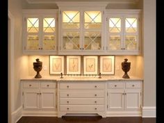 a kitchen with white cabinets and lights on the windows above it's counter tops