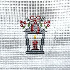 a cross stitch christmas card with a red candle