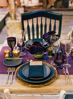 the table is set with purple and gold place settings