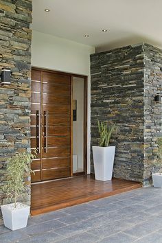 two large white planters sitting next to a wooden door