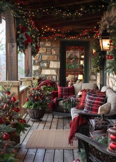 the porch is decorated for christmas with red and green decorations, plaid pillows, garlands and lights