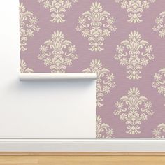 a wall with a purple and white damask pattern on it, next to a wooden floor