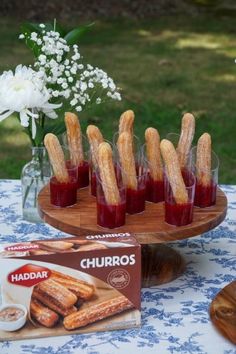 some churros are sitting on a table next to other snacks and drinks in glasses