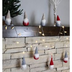 christmas decorations hanging on a brick wall in front of a fireplace with lights and stars