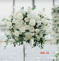 a vase filled with white flowers sitting on top of a table next to another vase