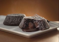 two chocolate desserts on a plate with a fork