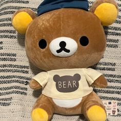 a brown teddy bear wearing a shirt with the word bear on it