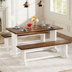 a dining table with two benches in front of it and flowers on the table top