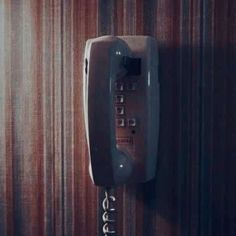 an old fashioned telephone is hanging on the wall