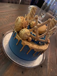 there is a blue cake with gold decorations on it