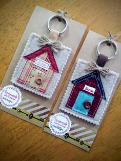 two key chains with small houses on them