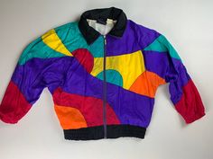 "Vintage 80's Multi Colored Windbreaker  Size Medium  Oversized Look Batwing Sleeve  Nylon  Made in Taiwan  Zipper closure  Elastic waistband and cuffs  Pockets  Vibrant colors  Great condition 26\" across the chest  19\" underarm to cuff 27\" from top of collar fold to hem" Retro Multicolor Windbreaker For Streetwear, Retro Nylon Windbreaker For Fall, Spring Multicolor Nylon Windbreaker, 90s Style Multicolor Windbreaker For Spring, Retro Multicolor Windbreaker For Fall, Retro Multicolor Windbreaker For Winter, Retro Multicolor Winter Windbreaker, Spring Multicolor Color Block Windbreaker, Vintage Multicolor Windbreaker For Fall