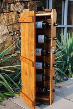 a wooden wine rack with six bottles in it