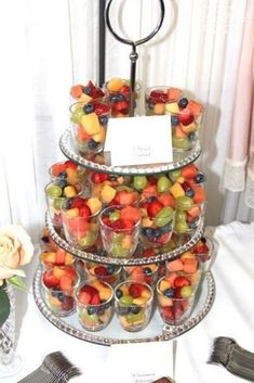 a tiered tray filled with fruit on top of a table