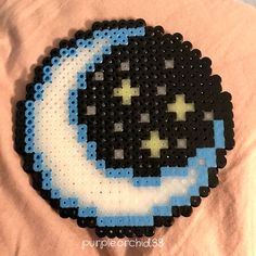 a black and white beaded object with a blue moon