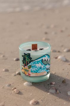 a small candle sitting on top of a sandy beach