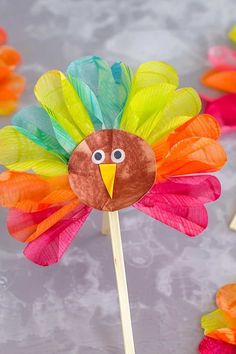 a paper turkey on a stick with colored feathers