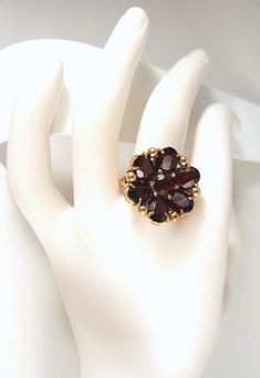 "IMPORTANT: A description is available following the details. Please, read on. Thank you. Material: 18 K solid gold, 6 oval-shaped faceted garnets measuring approximately 8mmx6mm; one round cut faceted garnet measuring approximately 6mm. Total 9.4cttw Size: 7 1/4 The face of the ring measures approximately a large 2.2mm (round) weight: 8.2g Period: 1900s, late Victorian, early Art Nouveau Provenance: an estate sale in Paris, France Condition: excellent estate, minor wear Additional remarks: stam Romantic Paris, Garnet Gem, Fine Gold Jewelry, Purple Band, 3 Things, Flower Ring, Rare Antique, Gold Engagement Rings, 10k Gold