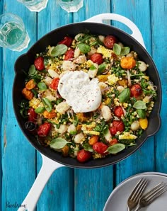 a skillet filled with vegetables on top of a blue table