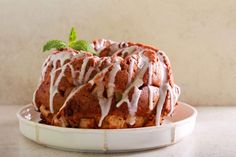 a bundt cake covered in icing and drizzled with green leaves