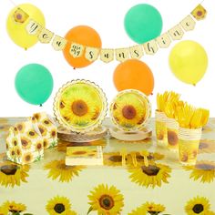 a table with sunflowers, balloons and other items on it for a birthday party