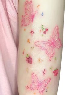 a girl with tattoos on her arm has pink butterflies and strawberrys painted on it