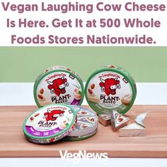 three yogurt cups sitting on top of a wooden cutting board with the words vegan laughing cow cheese is here get it at 50 whole foods stores nationwide