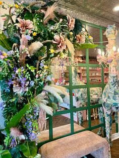 a floral display in a store filled with lots of greenery and flowers on the wall